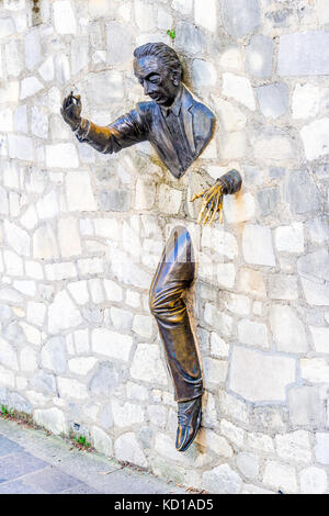 The Passe-Muraille, stucked into the wall of the Marcel Aymé place, is a statue made by the actor Jean Marais, as a tribute to Marcel Aymé. Stock Photo