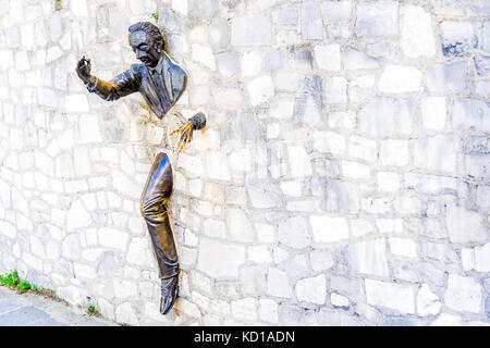 The Passe-Muraille, stucked into the wall of the Marcel Aymé place, is a statue made by the actor Jean Marais, as a tribute to Marcel Aymé. Stock Photo