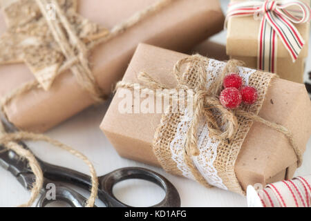 Christmas gifts wrapped in brown craft paper with festive decorations Stock Photo