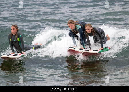 Three teenage girls on their surfboards surfing the waves,Sydney,Australia Stock Photo