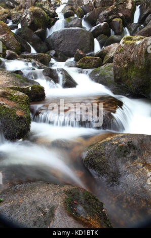 water flowing over rocks in Becka Brook at Becky Falls, Manaton, Devon Stock Photo