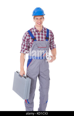 Portrait Of Young Happy Male Architect Holding Blueprints And Toolkit Stock Photo