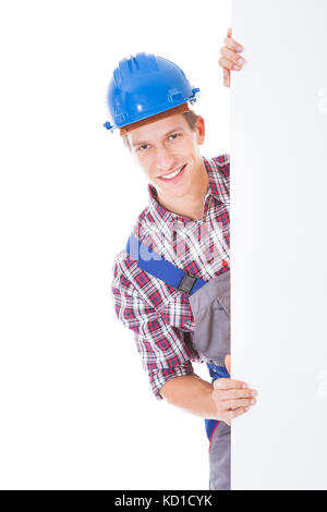 Portrait Of Young Male Worker Holding Placard Over White Background Stock Photo