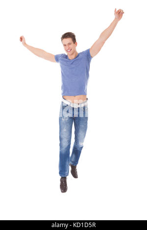 Portrait Of Excited Young Man With Hand Raised Over White Background Stock Photo