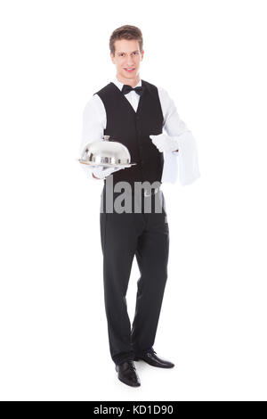Young Male Waiter Holding Cloche Lid Cover Over White Background Stock Photo