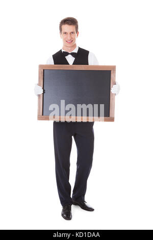 Young Male Waiter Holding Chalkboard Over White Background Stock Photo