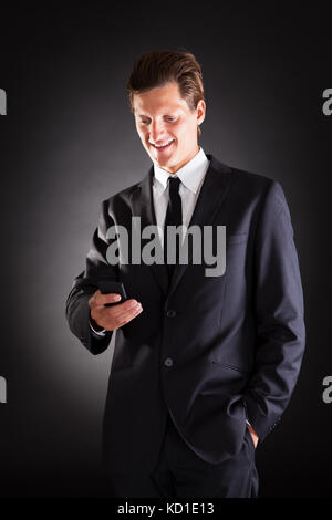 Happy Young Man Using Cellphone Over White Background Stock Photo