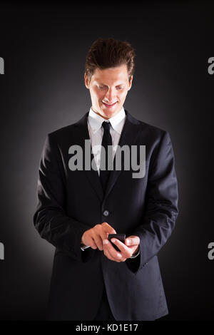 Happy Young Man Using Cellphone Over White Background Stock Photo