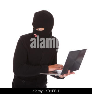 Portrait Of A Burglar Using Laptop Isolated On White Background Stock Photo