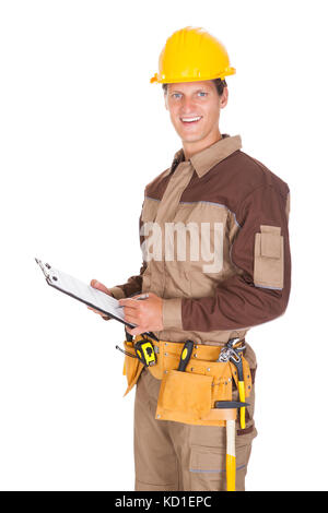 Happy Young Mechanic In Protective Workwear Writing On Clipboard Stock Photo