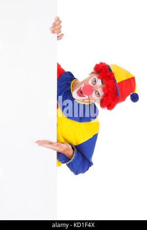 Portrait Of A Happy Joker Holding Blank Placard Over White Background Stock Photo