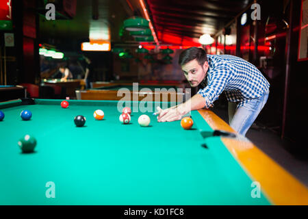 Hansome man playing pool in bar alone Stock Photo