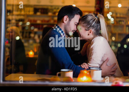 Happy couple kissing at bar and having date Stock Photo