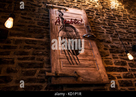 Old abandoned restaurant - vintage sign entrance door with text a table and fork spoon on brown brick wall Stock Photo