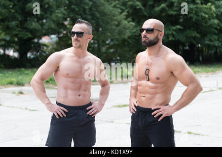 Fit couple showing muscles Stock Photo - Alamy