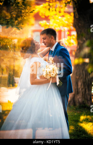 couple groom and bride against the background of orange leaves Stock Photo