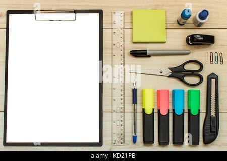 office accessories on wooden table. Markers, a tablet, a knife, scissors, stickers. Stock Photo