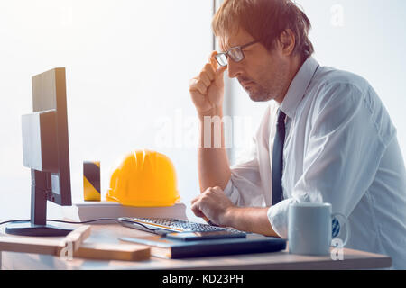 Construction engineer working on desktop computer using CAD software to sketch project in architecture studio office Stock Photo