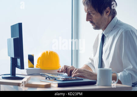 Construction engineer working on desktop computer using CAD software to sketch project in architecture studio office Stock Photo