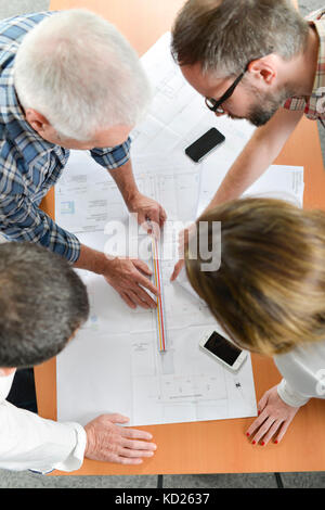 Group of architects gathered around a desk Stock Photo