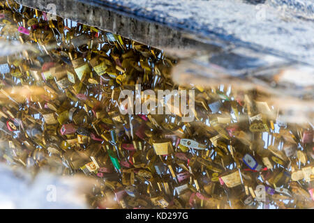 Love locks on a bridge on the  Île de la Cité in Paris. A love lock is a padlock that sweethearts lock to a bridge, fence, gate, or monument. Stock Photo