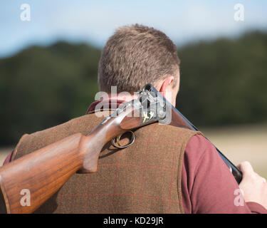 man carrying shotgun on a pheasant shoot Stock Photo