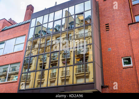 Beautiful apartments on a Paris street are reflected in windows of a more modern style. Stock Photo