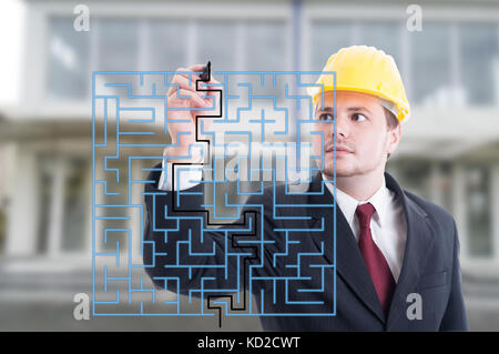 Handsome engineer solving a virtual puzzle with marker on digital screen Stock Photo