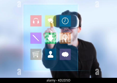 Modern guy wearing 3d headset glasses and pressing on futuristic screen with digital icons Stock Photo