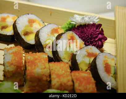 Japanese cuisine - Sushi rolls in the case at buffet restaurant. Stock Photo