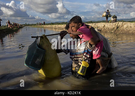 October 9, 2017 - 09 October 2017 Cox's Bazar, Bangladesh - Hundreds of Rohingya people crossing Bangladesh's border as they flee from Buchidong at Myanmar after crossing the Naf River in Bangladesh. According to the United Nations High Commissioner for Refugees (UNHCR) more than 525,000 Rohingya refugees have fled from Myanmar for violence over the last month with most of them trying to cross border reach Bangladesh. International organizations have reported claims of human rights violations and summary executions allegedly carried out by the Myanmar army. (Credit Image: © K M Asad via ZUMA Stock Photo