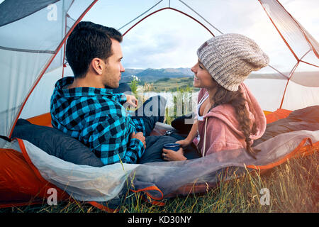 Couple relaxing in tent, rear view Stock Photo