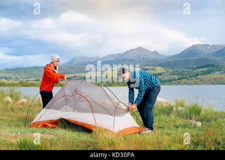 Couple in rural setting, putting up tent, Heeney, Colorado, United States Stock Photo