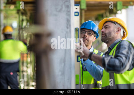 Project manager and construction worker using spirit level Stock Photo