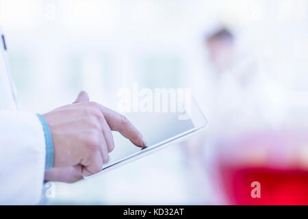 Laboratory worker using digital tablet, mid section Stock Photo