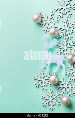 Elegant Christmas New Year Greeting Card Poster White Reindeer Snow Flakes Ball on Light Turquoise Blue Background. Copy Space. Scandinavian Style. Cr Stock Photo