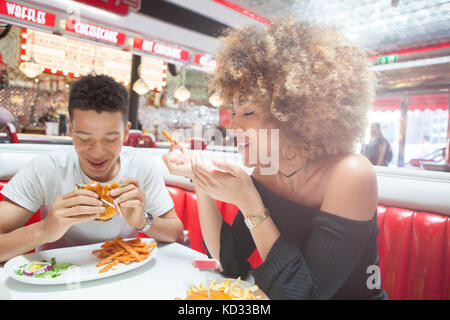 Young couple, sitting in diner, eating meal Stock Photo