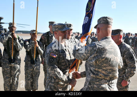 S.C. Army National Guard Soldier, Col. James Barkley, state aviation officer, passes the battalion colors from Lt. Col. James R. Fidler, the outgoing commander, to Maj. (P) John W. McElveen, the incoming commander during a Change of Command Ceremony held Feb. 8, 2015, at the Army Aviation flight facility at McEntire Joint National Guard base, Eastover, South Carolina. The purpose of the Change of Command Ceremony is to pass the command of the unit to the new commander, thus the passing of responsibility over equipment and personnel. Furthermore, the passing of the unit colors emphasizes that t Stock Photo