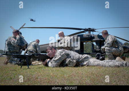 Soldiers assigned to Company A, 1-111th General Aviation Support Battalion, South Carolina Army National Guard, establish a perimeter defense around a U.S. Army UH-60 Black Hawk helicopter as part of a personnel recovery and downed aircraft training exercise at the McCrady Training Center, Eastover, S.C., May 3, 2015. The training enabled aircrews to build experience and confidence in personnel recovery procedures in conjunction with executing Army Warrior Tasks to ensure the Battalion is prepared for situations arising from either CONUS or OCONUS deployments. (U.S. Army National Guard photo b Stock Photo