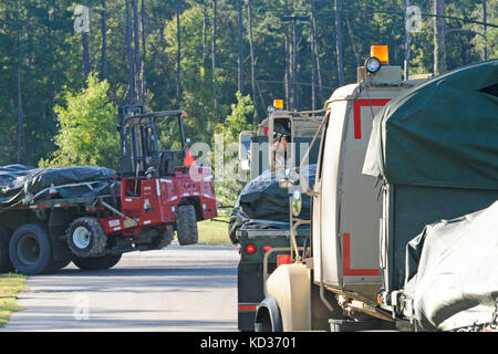 M915 Line-Haul Tractor Trucks from the 1052nd Transportation Company, South Carolina National Guard deliver sandbags to the 8 Oaks Park in Georgetown, S.C., Oct. 7, 2015. The sandbags were delivered in response to widespread flooding in the area as a result of heavy rain. The South Carolina National Guard partnered with federal, state and local emergency management agencies and first responders to provide assistance. (U.S. Army National Guard photo by Sgt. Kevin Pickering/Released) Stock Photo