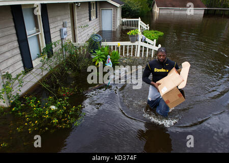 NFL player Clifton Geathers with the Pittsburgh Steelers retrieves any possessions not destroyed by the flood at his family home in Brown's Ferry near Georgetown, South Carolina, Oct. 10, 2015. The South Carolina National Guard has been activated to support state and county emergency management agencies and local first responders as historic flooding impacts counties statewide. Currently, more than 3,000 South Carolina National Guard members have been activated in response to the floods. (U.S. Air National Guard photo by Tech. Sgt. Jorge Intriago/Released) Stock Photo