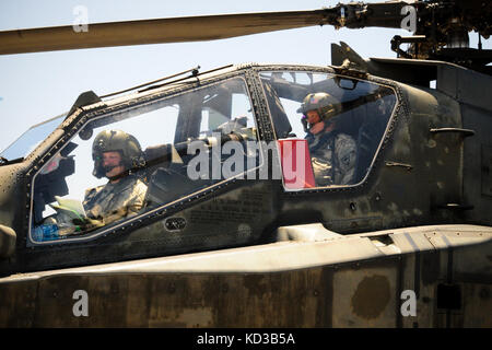 U.S. Army AH-64D Apache pilots assigned to S.C. Army National Guard’s 1/151 Attack Reconnaissance Battalion prepare to take-off at the forward arming and refueling point at Ft. Stewart, Ga., on May 4, 2014, to begin air-to-ground gunnery exercises as part of the unit’s annual training. Crews were tested with a variety of scenarios where they fired 30mm ammunition and point detonation rockets. (U.S. Army National Guard photo by. Sgt. Brian Calhoun/Released) Stock Photo