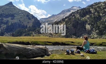 A young woman rests on the Posets Madaleta National Park, with de Mount Aneto in the background, Spain. Credit: Alamy / Karal Pérez Stock Photo