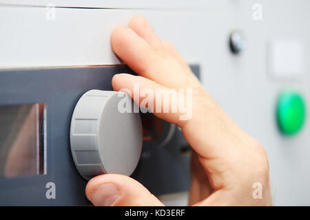 Engineer hand on control panel closeup. Engineer configure system controller. Stock Photo