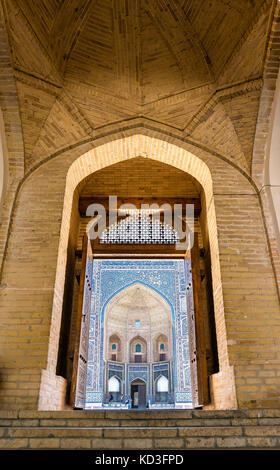 View of Mir-i Arab Madrasa through the doorway of Kalyan Mosque in Bukhara, Uzbekistan Stock Photo
