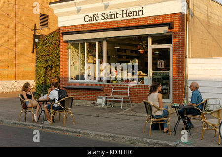 People talking at cafe table outside the Cafe Saint Henri coffee shop across from the Jean Talon Market, Montreal, Quebec Canada Stock Photo