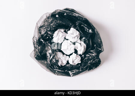 Garbage bag with crumpled pieces of paper on a white background top view Stock Photo