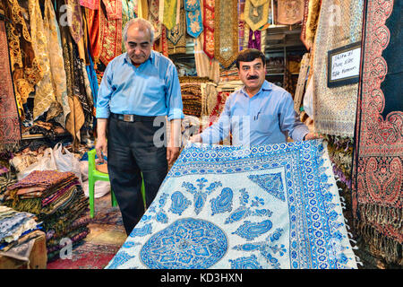 Fars Province, Shiraz, Iran - 19 april, 2017: Decorative textiles department at the city market, the Iranian dealer shows his wares. Stock Photo