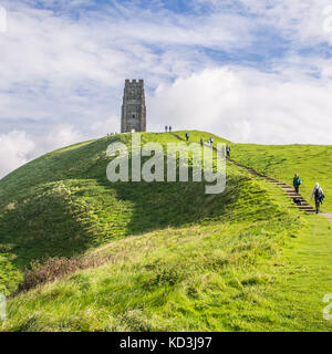 Hikers on Glastonbury Tor, a hill near the town of Glastonbury, Somerset, England. St Michael's Tower. Stock Photo