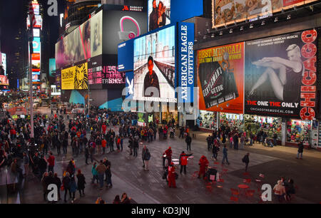 NEW YORK - MARCH 30: Tourists enjoy a walk down landmark Times Square in New York City, USA on cold night Marh 30, 2015 Stock Photo